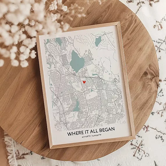 Where It All Began custom map poster on a wooden table with a heart marking a meaningful location.