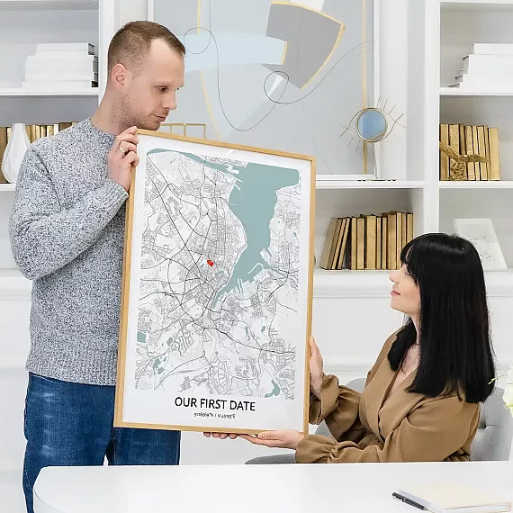 Couple sharing Our First Date Map poster showing a marked location from their first date.