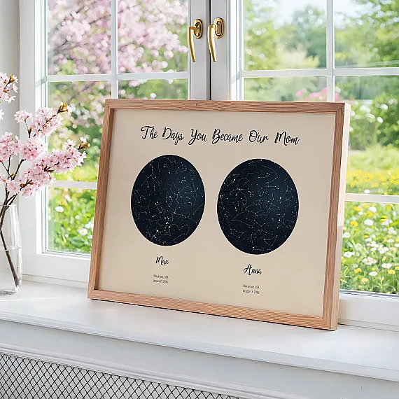 Framed night sky poster by a window showing the days you became our mom with two circular star maps.