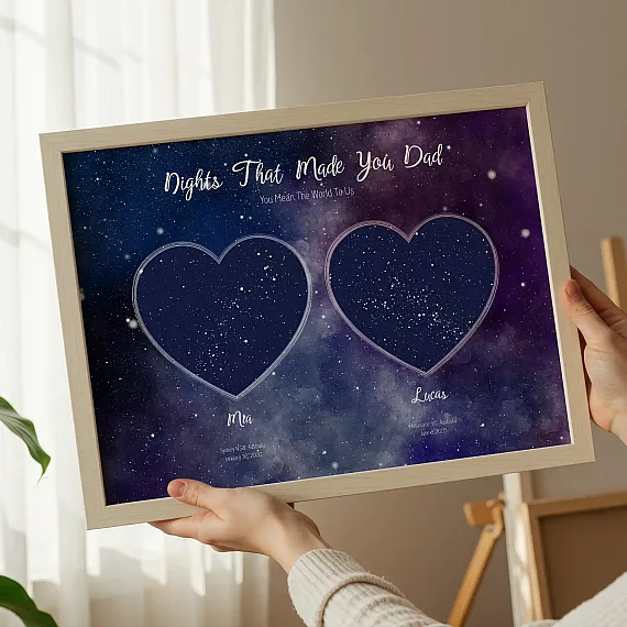 Galaxy-themed double heart star map poster held in hands indoors.
