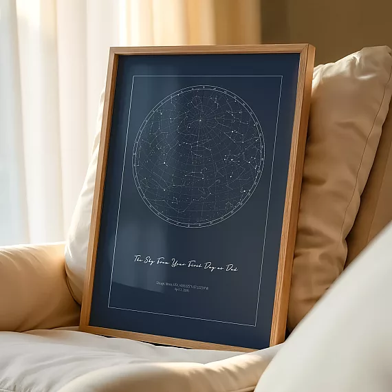 Framed The Day You Became My Daddy night sky print resting on a cream sofa beside soft pillows.