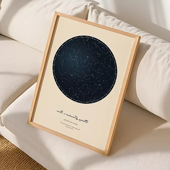Minimalistyczna personalizowana mapa nieba w drewnianej ramie oparta na jasnej kanapie