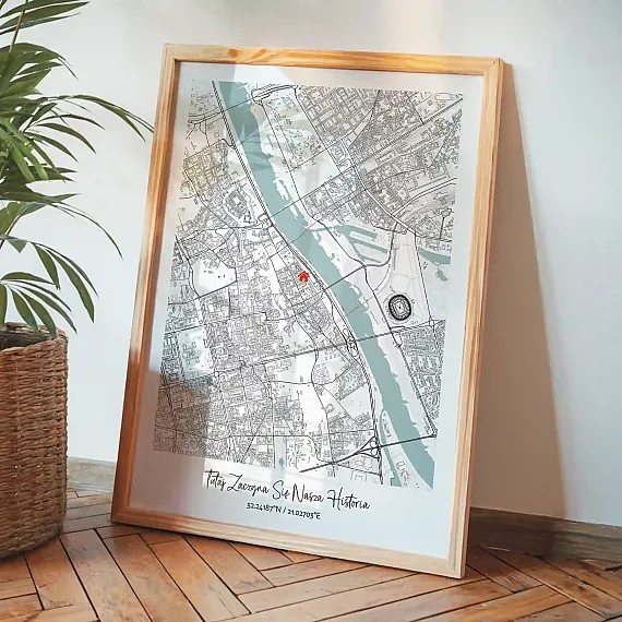 Personalizowana mapa miasta w drewnianej ramie oparta o ścianę obok rośliny