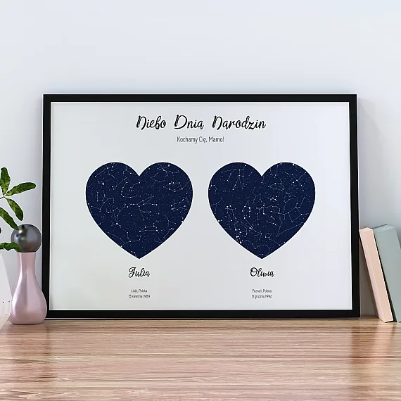Plakat z dwiema mapami nieba w kształcie serca ustawiony na drewnianej komodzie