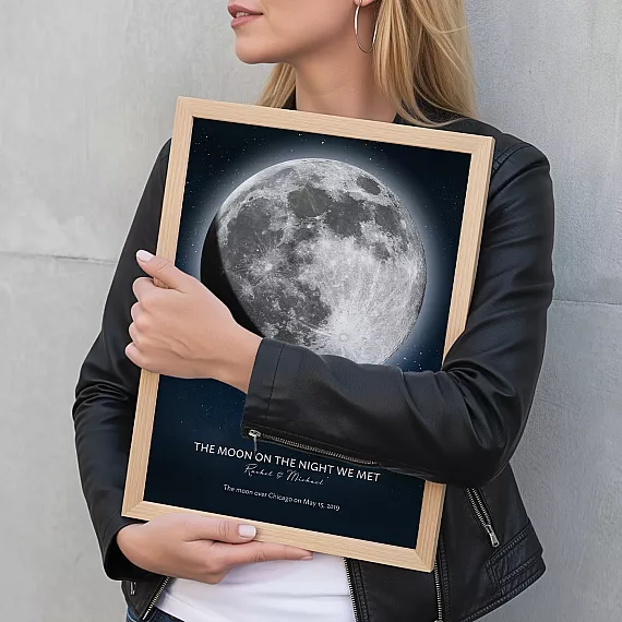 Woman holding a framed personalized Moon on the Night We Met print.