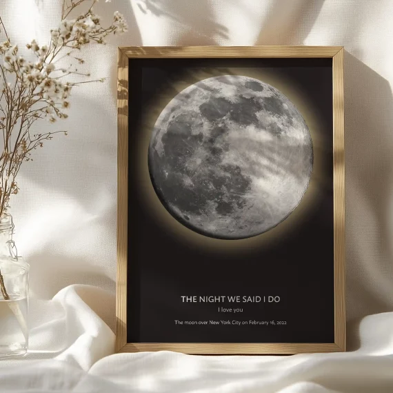 Personalized moon phase poster leaning against a wall in a bedroom with a large moon design.