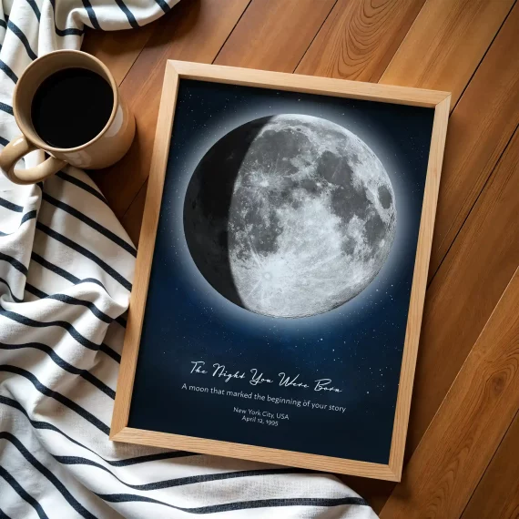 Flat lay birthday moon poster with coffee cup and striped fabric on wooden floor.