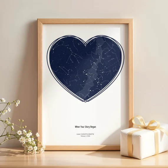 Heart-shaped Birthday Star Map print in wooden frame beside gift box and flowers.