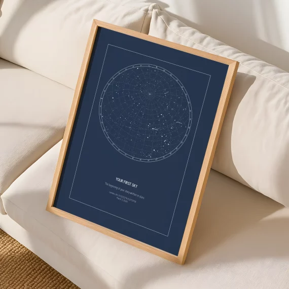 Minimalist navy blue star map print leaning against a white sofa.