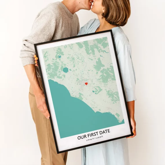 Couple holding Our First Date Map poster with a heart marking the place they first met.