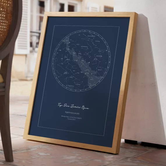 Granatowa mapa nieba w drewnianej ramie oparta o ścianę na tarasie