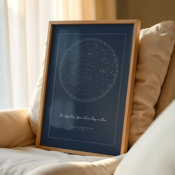 Framed The Day You Became My Daddy night sky print resting on a cream sofa beside soft pillows.
