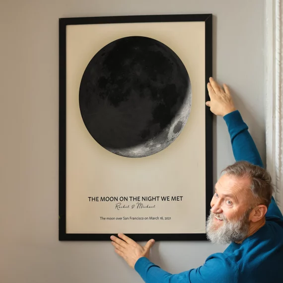Personalized Moon on the Night We Met print with a new moon displayed on a wall.