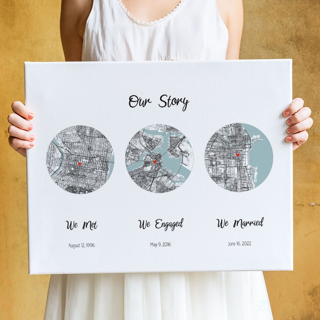 Woman holding a personalized three-map canvas that celebrates a love story through the places where a couple met, got engaged, and married