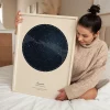 Woman holding a framed The Day You Were Born star map
