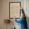 Grandfather displaying a framed personalized line art portrait of his grandchildren, featured among 12 personalized Christmas gift ideas for 2026.