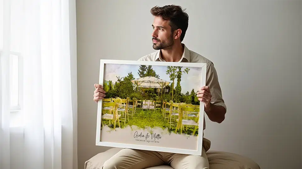 Regali di Natale personalizzati per lui poster acquerello luogo matrimonio Giulia Mattia uomo seduto con poster incorniciato.