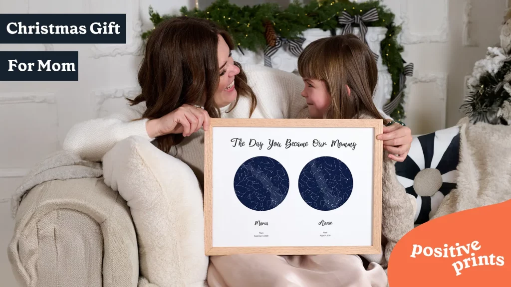 Personalized Christmas gift for mom featuring two custom star maps with children’s names and birth dates, held by a mother and daughter.
